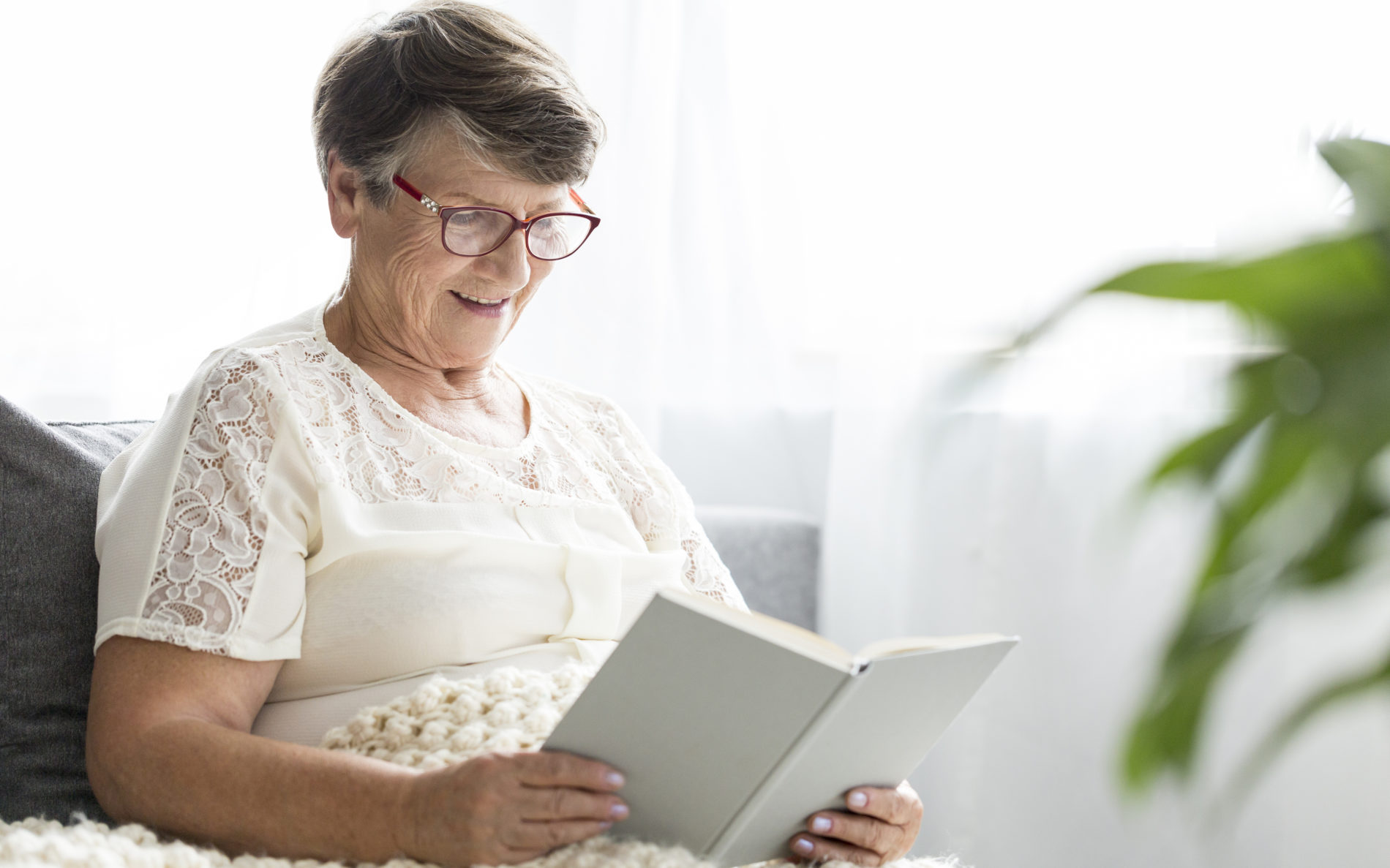 Senior woman reading a book in retirement home