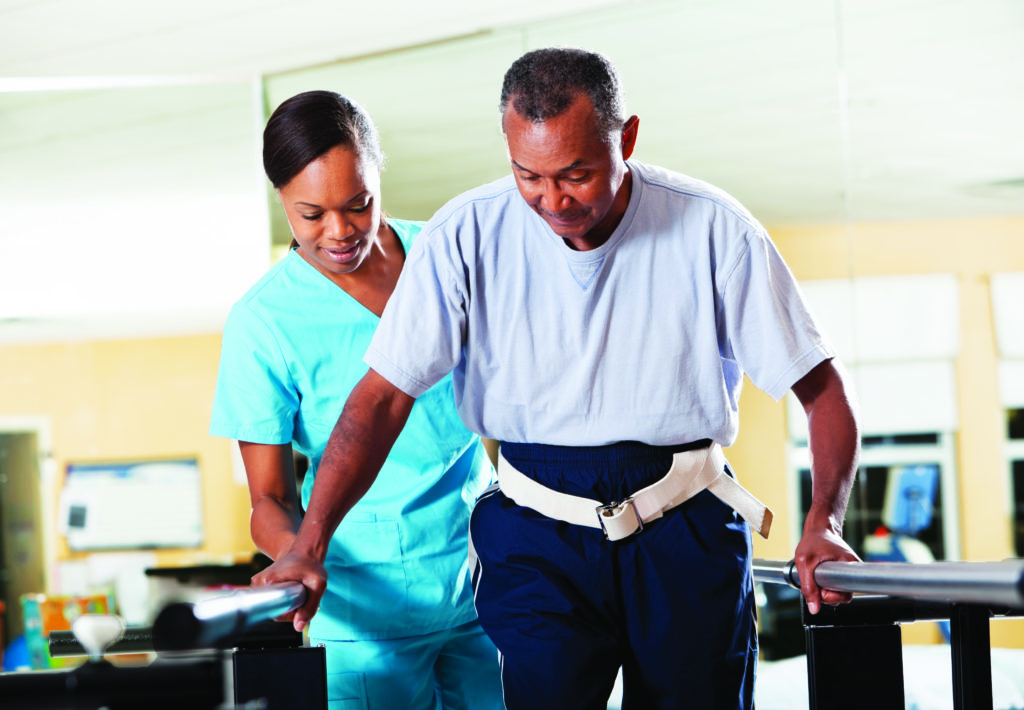 Physical therapist helping patient through gait training.