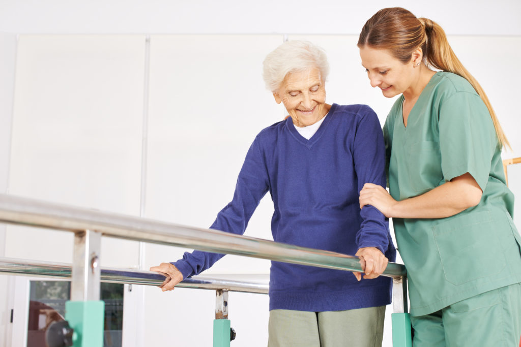 Senior female exercising with the help of physical therapist