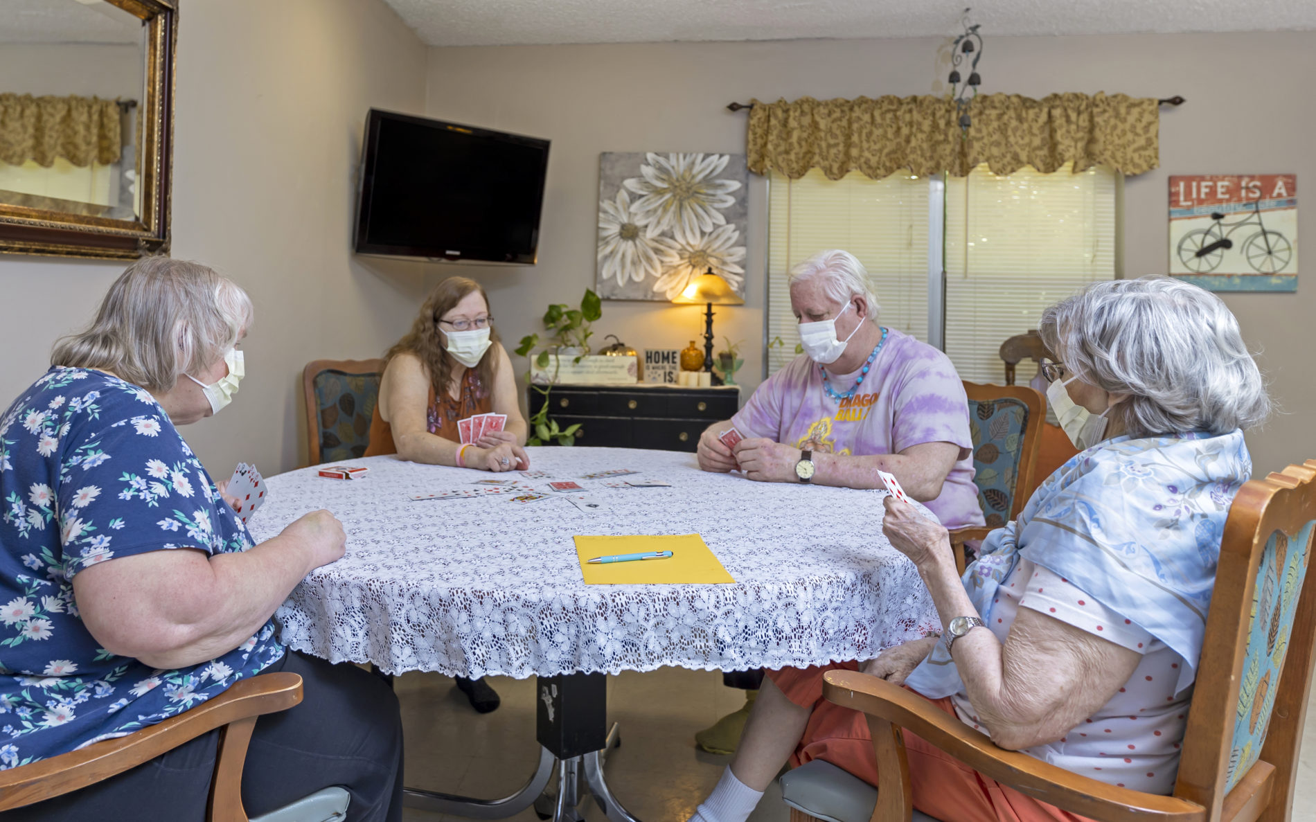 Seniors with masks playing cards
